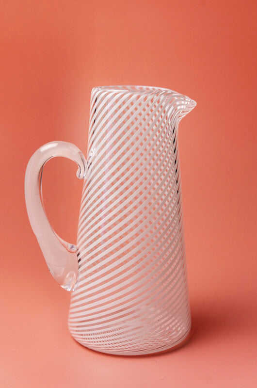 A small jug with white filigrana cane decoration, which was invented by Venetian glassblowers on the island of Murano in the early 16th century. This glass is made in the only artisanal glassblowing studio in Northern Ireland.