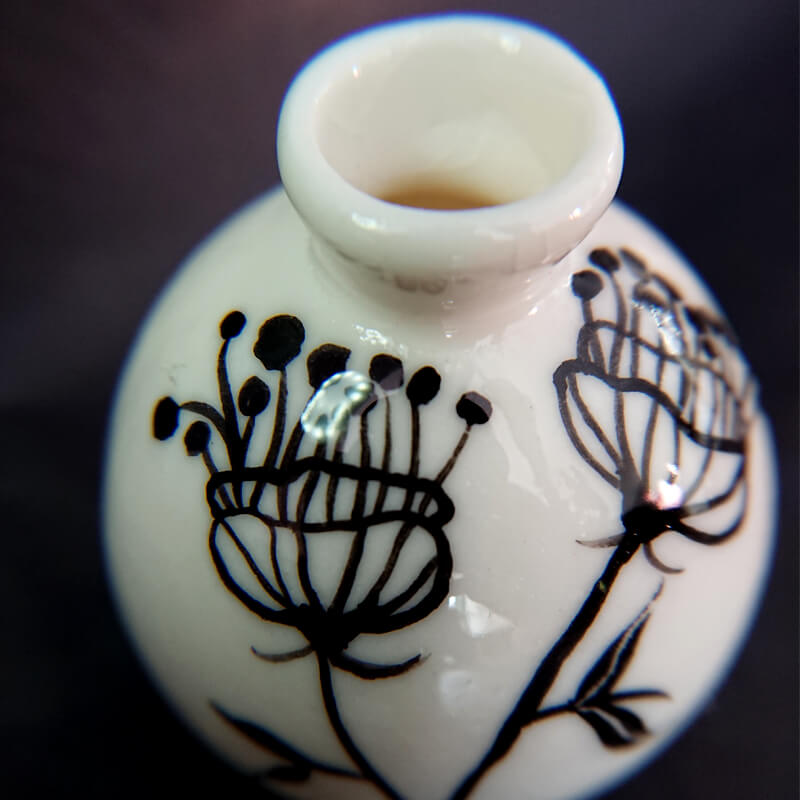 A tiny fine porcelain vase with glazed flower painting.  